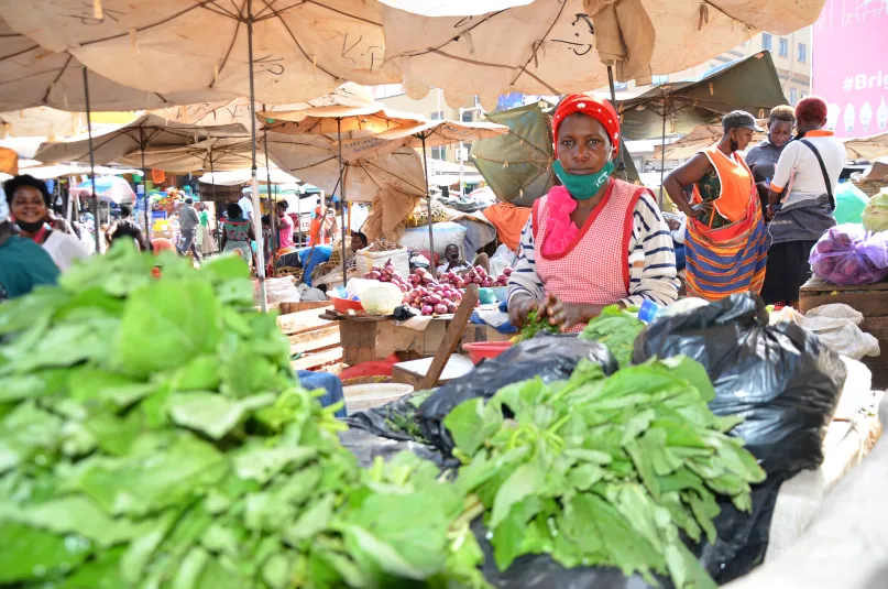 Woman selling vegetables at market.