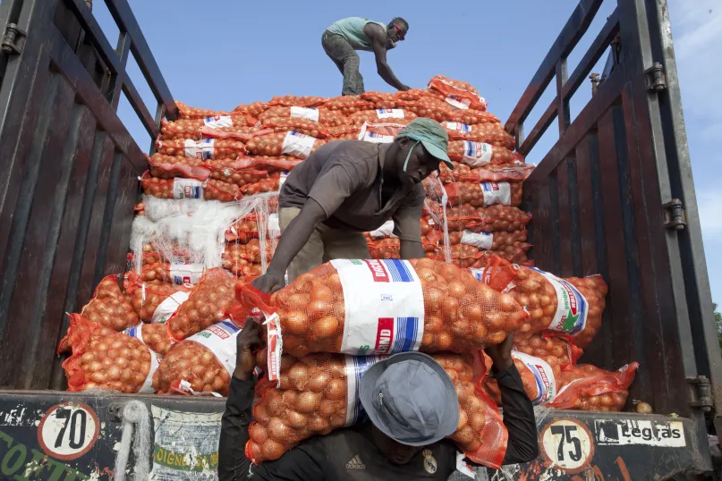 Des hommes déchargent des sacs d'oignons à Bamako au Mali.