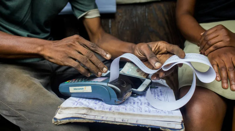 Les mains d'un agent de mobile money et de sa client au Nigéria. 