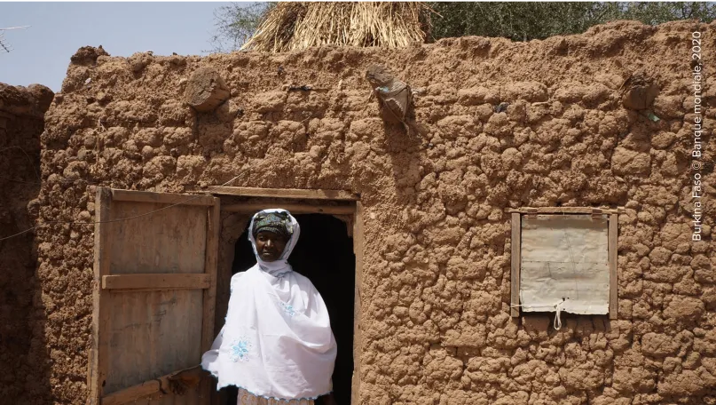 Une femme devant sa maison au Burkina Faso.