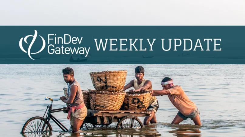 Pushing a cart in the water. Photo by Anindya Majumdar, 2016 CGAP Photo Contest.