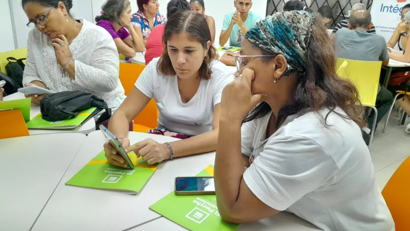 Dos mujeres migrantes explorando su celular.