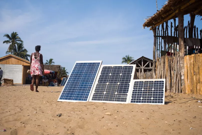 Solar panels resting in the sand.