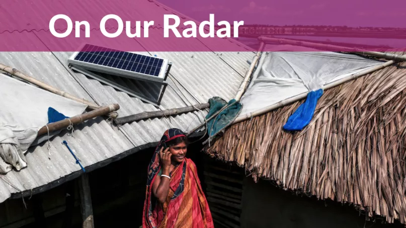 Woman talks on phone under rooftop solar panel