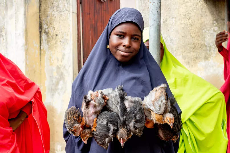 A woma holds a chicken