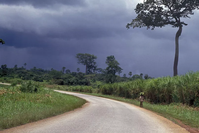 A woman walking on a rural road. Photo by Curt Carnemark, World Bank.