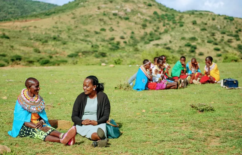 Rose Lelesiit (left) talking to her BOMA Village Mentor Sarah Sein Lanyasunya, in Maralal, Kenya at a meeting of Rose’s Savings Group. Photo credit: Jane Klonsky for the BOMA Project.