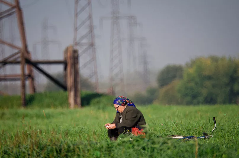 Mujer usando teléfono. Por Mihail Kopychko, Concurso de Fotografía CGAP 2015.