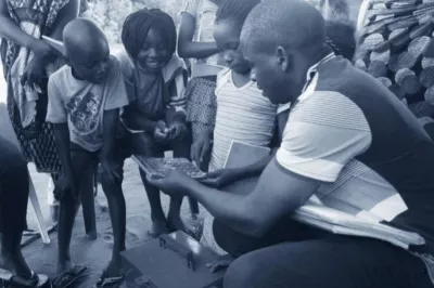 Young people looking at a calculator. Photo by Child and Youth Finance International