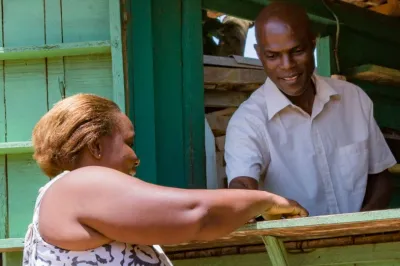 Man mobile money agent assisting woman customer.