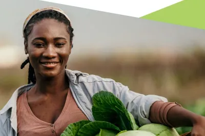 Woman smiling and holding a basket of cabbage.