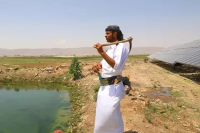 Un homme avec un outils contemple un champ au Moyen-Orient.