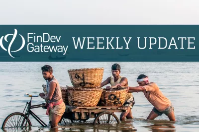 Pushing a cart in the water. Photo by Anindya Majumdar, 2016 CGAP Photo Contest.