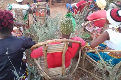 Women sitting on chairs in the open air.