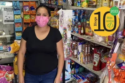 Mujer de tapabocas ante los anaqueles de su pequeño almacén en México.