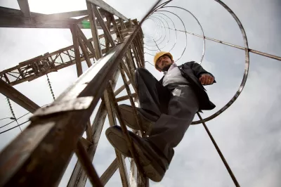 A man working at a construction site on a ladder, World Bank photo.