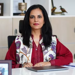 Roshaneh Zafar, Founder of Kashf Foundation in Pakistan, sitting at a desk.