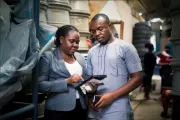 Man and woman in warehouse looking at tablet.