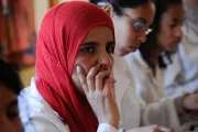 Woman in a head scarf listens to a training