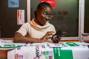 A woman operates a Point of Sale (POS) machine in her shop in Nigeria. Temilade Adelaja, 2020 CGAP Photo Contest.