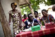 People smiling at a savings group meeting.