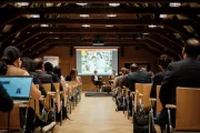 View down the center aisle of wood-paneled conference room at European Microfinance Week