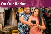 Two women stand together looking at a phone screen