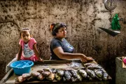 A woman and her daughter selling fish.