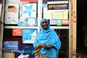 Woman stands outside of a bank in the suburbs of Dakar.